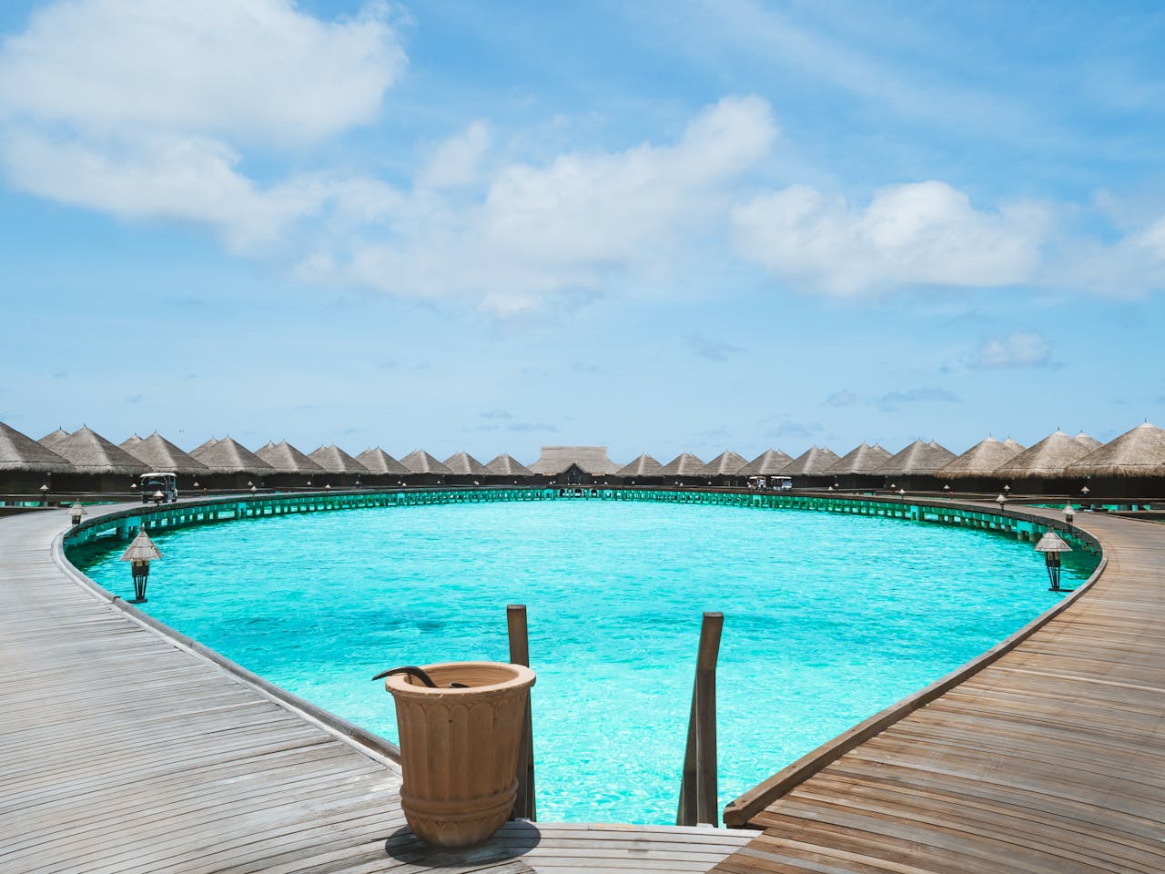 Scenic view of overwater bungalows and turquoise lagoon under clear skies, perfect for a tropical getaway.