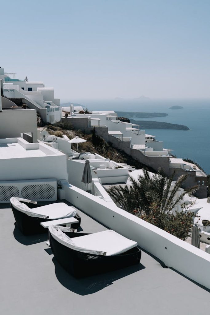 Luxurious terrace overlooking Santorinis iconic white buildings and deep blue sea.