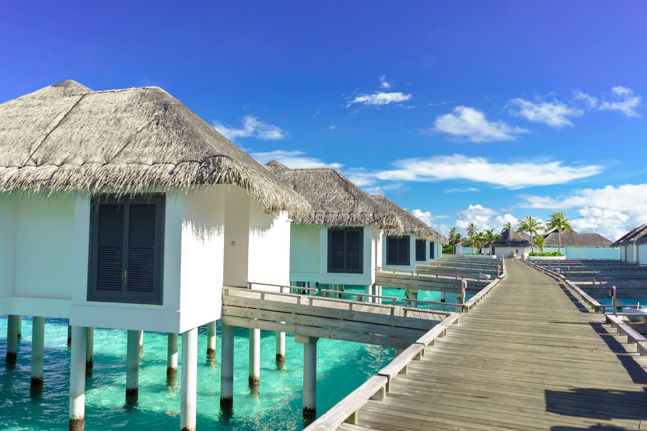 Scenic view of luxurious overwater bungalows on a sunny tropical day, ideal for travel and relaxation.
